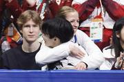 　ミラノ五輪団体男子ＳＰの演技を終え、カロリナ・コストナー・コーチ（奥）に抱きしめられる鍵山優真＝２月、ミラノ（共同）