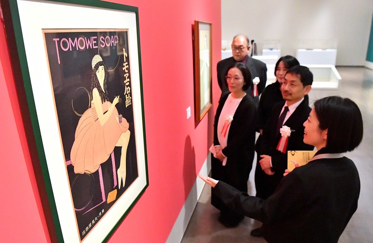 「大正・昭和モードの源泉」展で、杉浦非水「トモエ石鹸」を鑑賞する出席者ら＝１８日午後２時２１分、岐阜市宇佐、県美術館（撮影・坂井萌香）