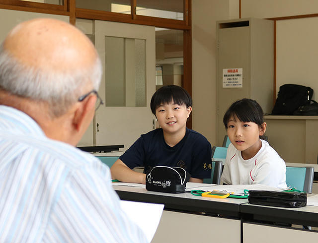 地元民謡保存会のメンバーから村伝統の民謡を学ぶ児童＝白川村平瀬、村南部地区文化会館