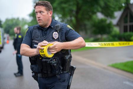 　ミネソタ州議会議員銃撃事件の現場近くに規制線を張る警察官＝１４日、ミネソタ州ブルックリンパーク（Ａｌｅｘ　Ｋｏｒｍａｎｎ／Ｓｔａｒ　Ｔｒｉｂｕｎｅ提供・ＡＰ＝共同）