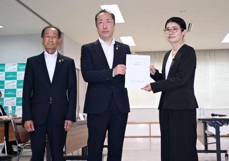 　国光文乃外務副大臣（右）に要請書を手渡す北海道の浜坂真一副知事（中央）と「千島歯舞諸島居住者連盟」の鈴木日出男副理事長＝１９日午後、北海道根室市
