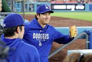　カージナルス戦で先発を外れ、ベンチで佐々木朗（手前）と言葉を交わすドジャース・大谷＝ロサンゼルス（共同）