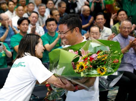 　沖縄県知事選で初当選を決め、花束を受け取る古謝玄太氏＝１３日夜、那覇市