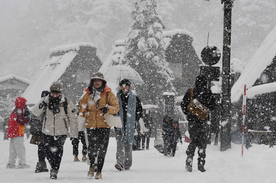 雪の中を歩く観光客＝２１日午後１時２１分、大野郡白川村荻町、合掌造り集落