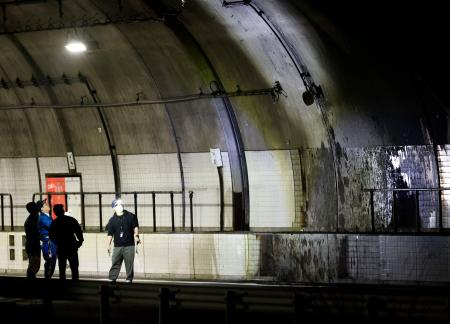 　事故の実況見分が行われた、新名神高速道路下り線の野登トンネル出口付近＝２４日深夜、三重県亀山市