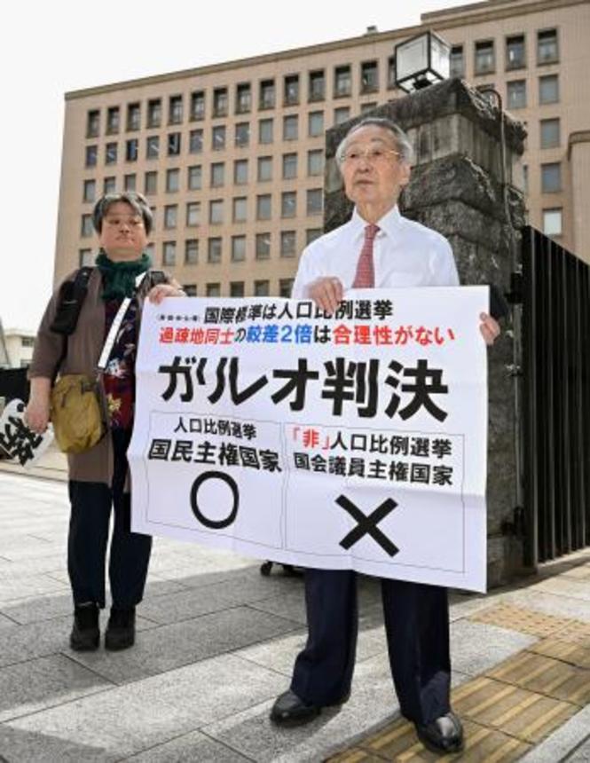 　衆院選「１票の格差」訴訟の判決を受け、仙台高裁前で「ガリレオ判決」などと書かれた紙を掲げる原告側の升永英俊弁護士（右）ら＝９日午後