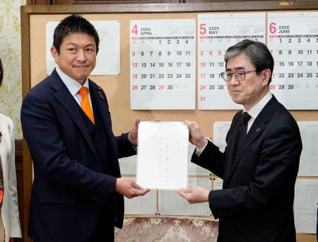 　日本国旗損壊行為への刑罰を明記した刑法改正案を伊藤文靖参院事務総長（右）に提出する参政党の神谷代表＝２日午後、国会