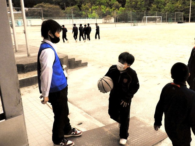 休み時間にボールの貸し出し場所に立ち、生徒らに声を掛けるいじめ対策監の永井隆史教諭（左）＝４月１６日、岐阜市芥見、藍川中学校