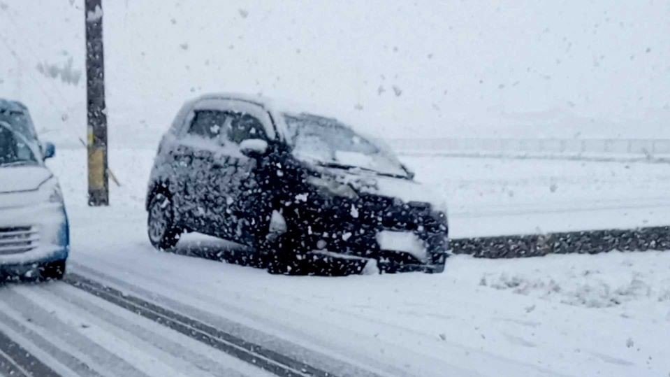  雪で滑ったのか、道路脇に脱輪して立ち往生した車＝１７日午前８時４０分、岐阜市北部