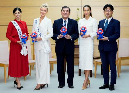 　２０２４年のミス・ユニバース世界大会優勝のビクトリア・ケア・テイルビヒさん（左から２人目）らと写真に納まる石破首相（中央）＝２３日午前、首相官邸