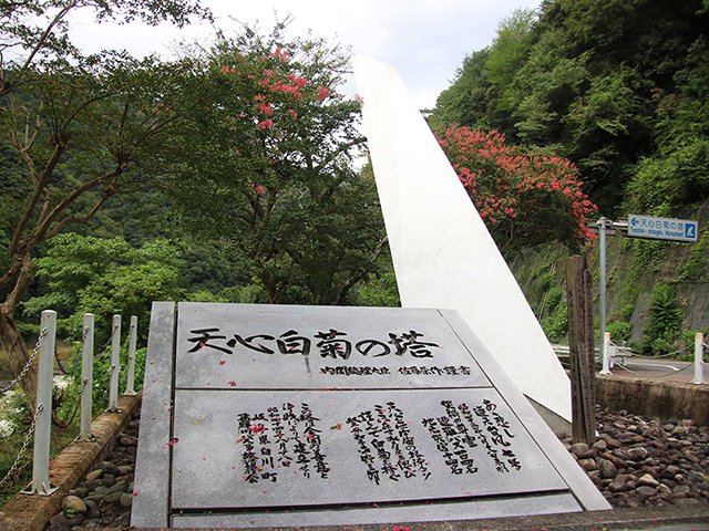 年度内に解体撤去される塔（奥）。手前は移転される石碑＝１８日午後４時１０分、加茂郡白川町河岐