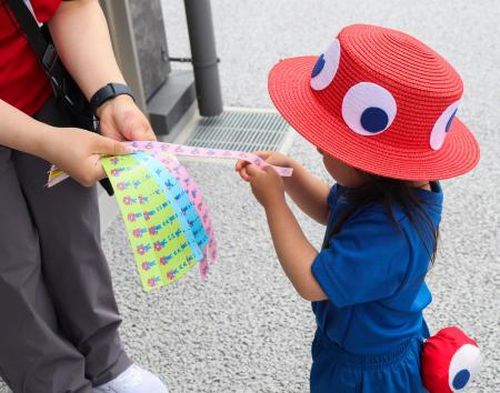 　万博会場で無料配布されている「まいごリストバンド」を選ぶ子ども＝５月、大阪市此花区の夢洲