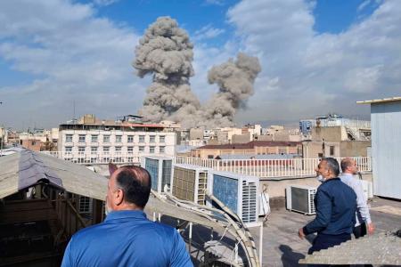 　イランの首都テヘランで爆発後に立ち上る煙を見る人たち＝２８日（ＡＰ＝共同）