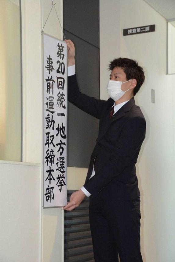 事前運動取締本部の看板を設置する捜査員＝県警本部