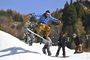 紅葉を背に初滑りを楽しむスノーボーダー＝３日午前１０時半、郡上市白鳥町石徹白、ウイングヒルズ白鳥リゾート