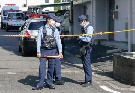 　女性の遺体が見つかった集合住宅の前に立つ警察官＝３０日、愛知県豊田市