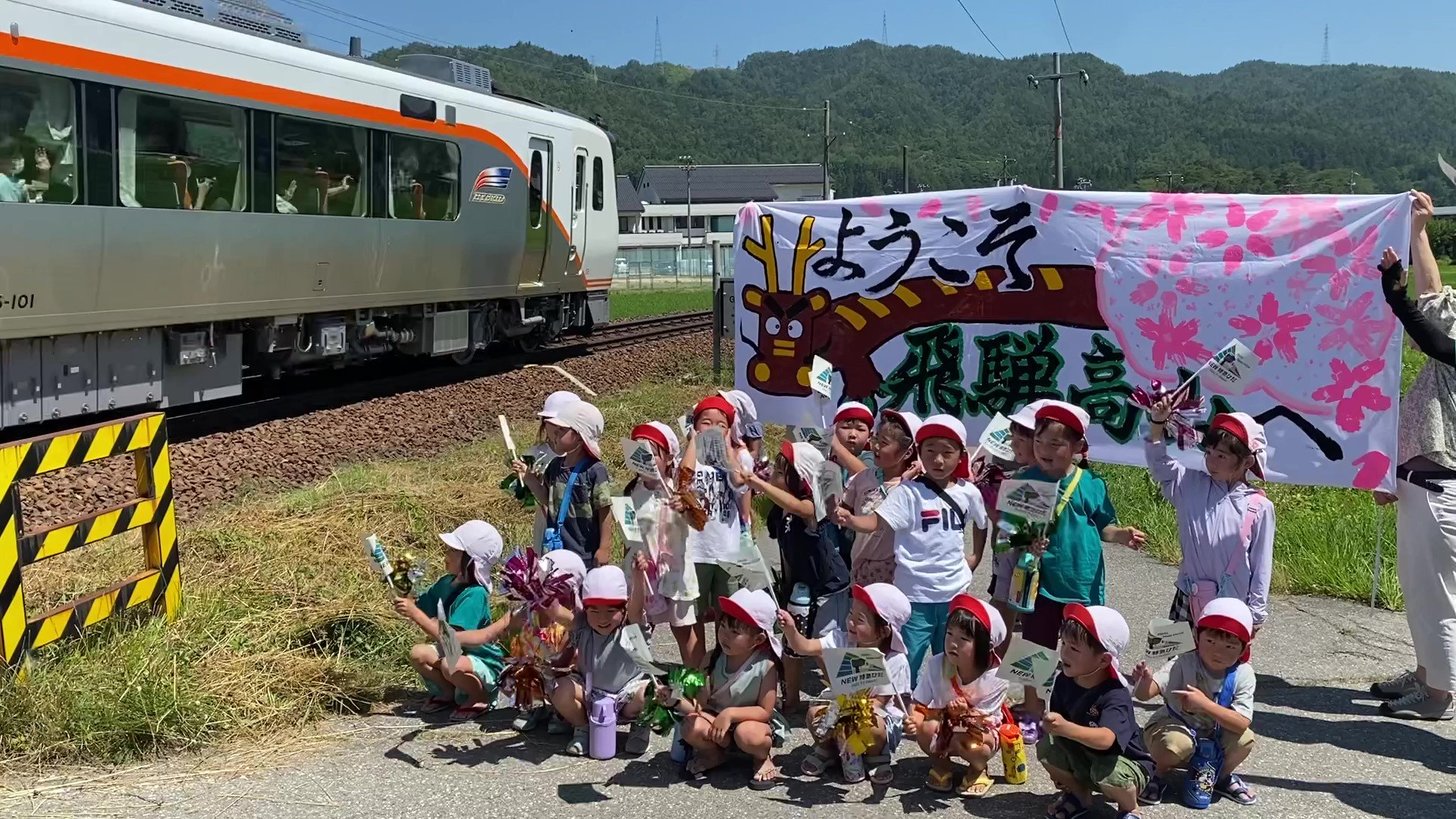 HC８５系（特急ひだ１号）を出迎える子どもたち＝１日午前、高山市一之宮町