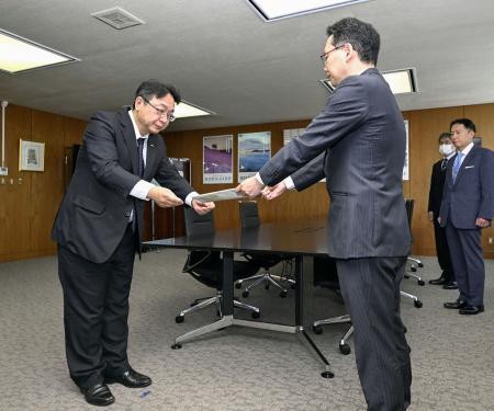 　国交省北海道運輸局の井上健二局長（右）に改善措置の進捗状況をまとめた報告書を提出するＪＲ北海道の綿貫泰之社長＝３０日午前、札幌市
