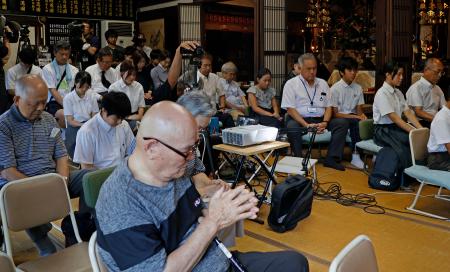 　恩楽寺で開かれた「模擬原爆」の犠牲者追悼式で黙とうする参列者＝２６日午前、大阪市東住吉区（画像の一部を加工しています）