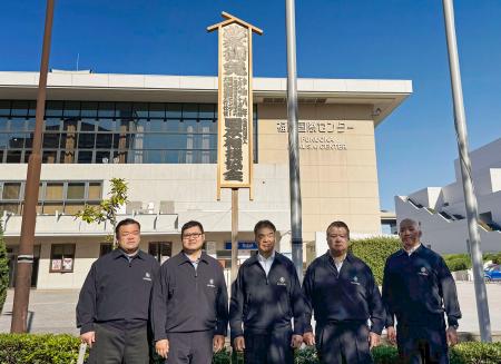 　大相撲九州場所の開催を知らせる「御免札」を設置した片男波親方（中央）ら＝８日、福岡国際センター