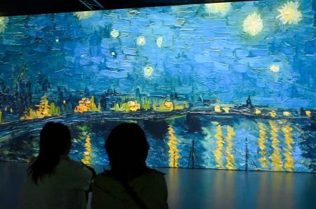　「イマーシブミュージアム高知」でスクリーンに映し出されたゴッホの「ローヌ川の星月夜」＝１７日午前、高知市