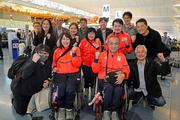 　見送りに来た人たちと笑顔で記念写真に納まる車いすカーリング混合ダブルスの小川亜希（手前左）、中島洋治（同右）組＝２８日、羽田空港