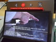 四つのボタンをセンサー式に切り替えたモニター。映像も新たに制作し、英語バージョンを加えた＝同
