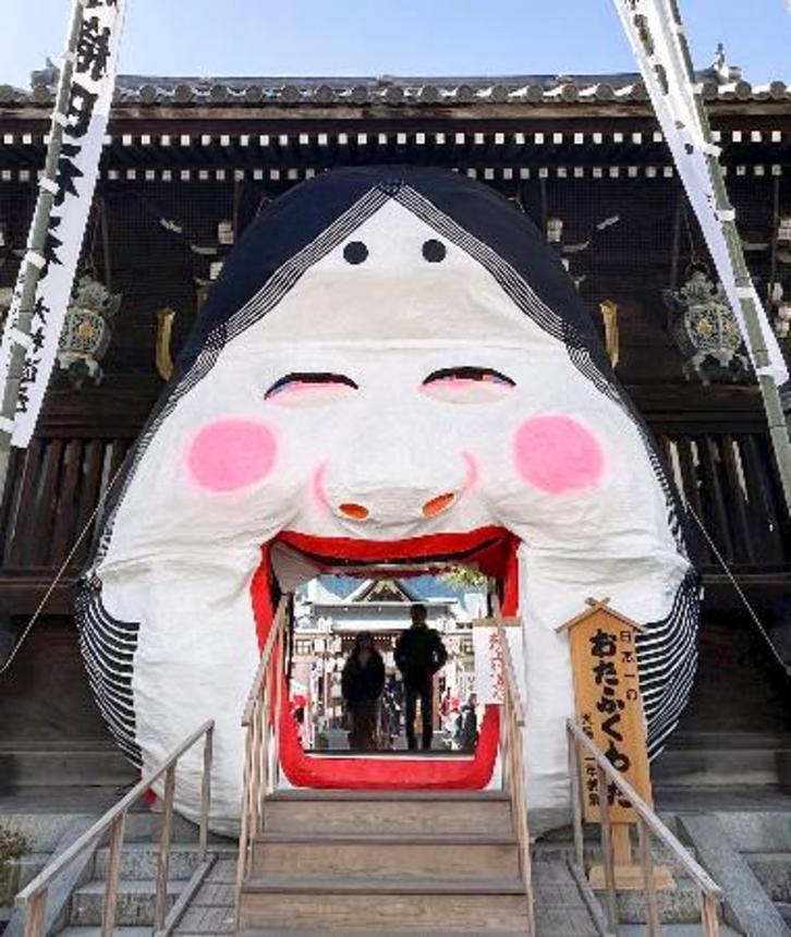 　福岡市博多区の櫛田神社に登場した毎年恒例の「大お多福面」＝３１日午後