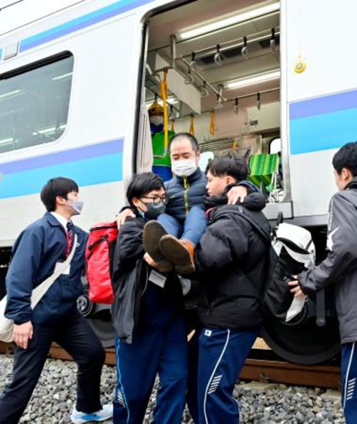 　ＪＲ仙石線で実施された津波を想定した避難訓練で列車から降りる乗客役＝２６日午後、宮城県東松島市