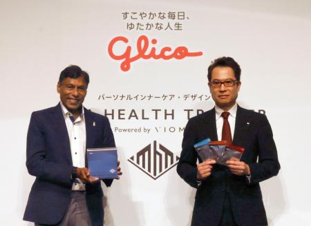 　記者会見で写真に納まる江崎グリコの江崎悦朗社長（右）ら＝９日午後、東京都内