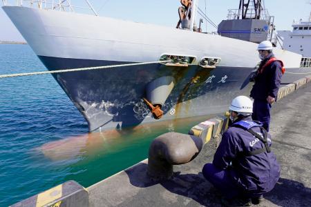 　貨物船末広丸の船首部分を調べる海保関係者＝１８日午前、青森県八戸市