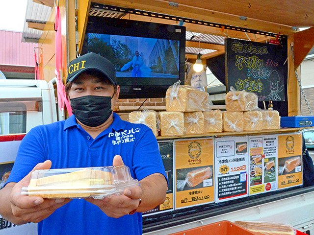 ヤマダパンの食パンを使った特製のだし巻きサンドを手にする橋爪亮太代表＝大垣市築捨町
