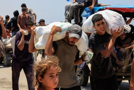 　９日、ガザ最南部ラファで、イスラエルと米国主導で配給する物資を受け取った人たち（ロイター＝共同）