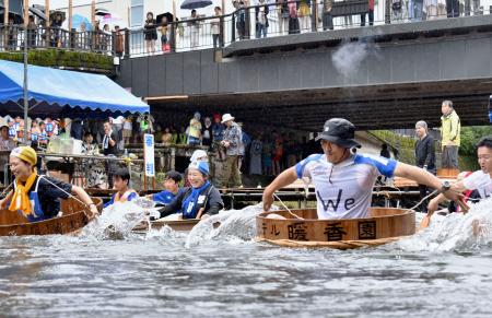 　「松川タライ乗り競走」で、大きなタライに乗り込み川を下る参加者＝５日午前、静岡県伊東市