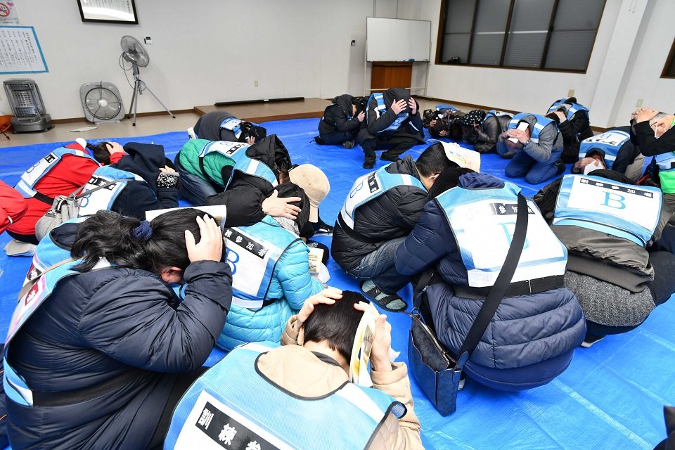 窓から離れ、頭を手で押さえて屈む住民たち＝海津市南濃町境、境区集会所