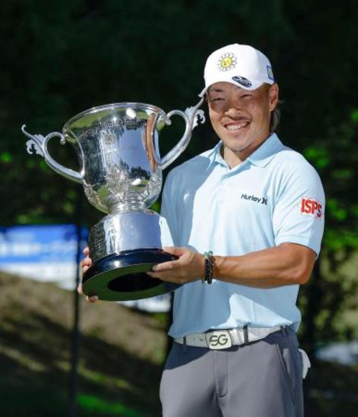 　通算９アンダーで優勝し、トロフィーを手に笑顔の藤本佳則＝茨木ＣＣ