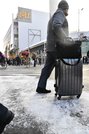 雪が舞う中を歩く人たち＝２５日午前８時７分、岐阜市神田町
