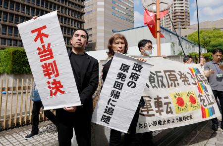 　関西電力大飯原発３、４号機を巡る訴訟の控訴審判決を受け、「不当判決」などと書かれた垂れ幕を掲げる住民側＝２８日午後、大阪高裁前