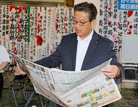 　群馬県高崎市の事務所で新聞を読む自民党の清水真人氏＝２１日午前