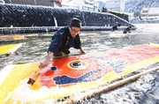 冷たい川の水でのりを落とすこいのぼりの寒ざらし作業＝１８日午前１０時６分、岐阜県郡上市八幡町、小駄良川