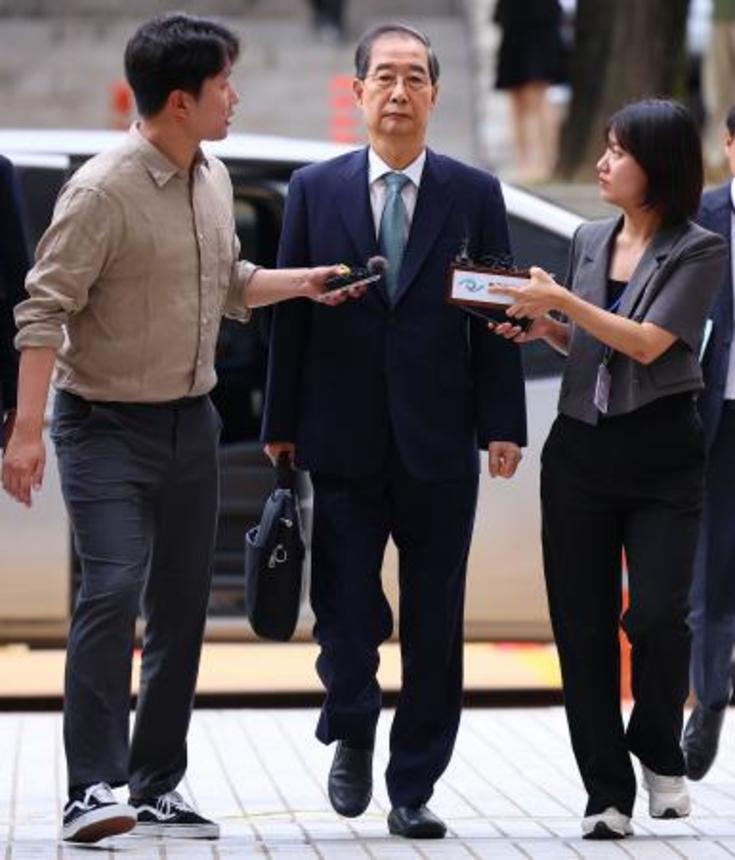 　２７日、ソウル中央地裁に到着した韓悳洙前首相（中央）（聯合＝共同）