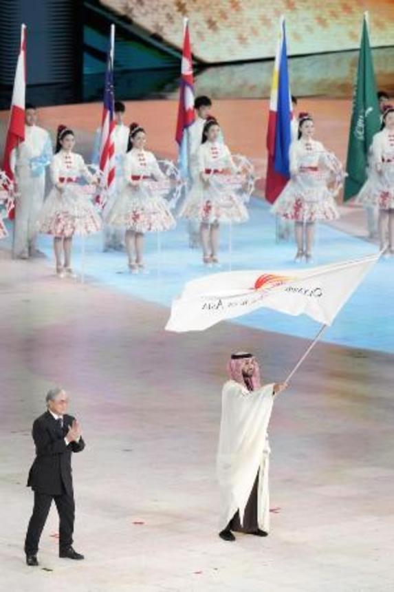 　昨年２月、ハルビン冬季アジア大会の閉会式で、次回開催地のサウジアラビアの関係者に引き継がれた大会旗＝中国・ハルビン