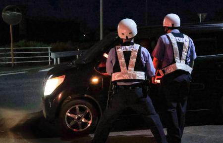 　住民に避難を呼びかける警察官＝１８日午後８時１０分、大分県中津市
