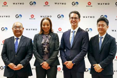 　完全無人タクシーの運行発表の記者会見に出席した、ウェイモのテキドラ・マワカナＣＥＯ（左から２人目）、ＧＯの川鍋一朗会長（同３人目）ら＝１５日午前、東京都千代田区