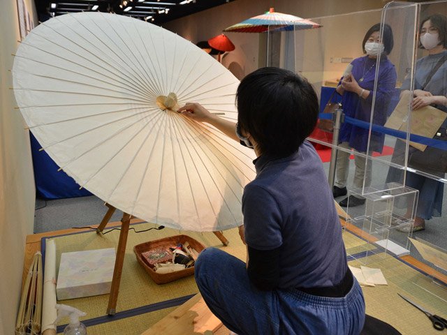 和傘作りを実演する職人＝美濃市蕨生、美濃和紙の里会館