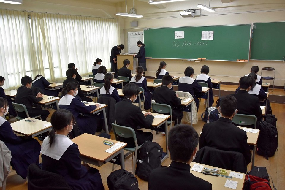 問題冊子の配布を待つ受験生たち＝岐阜市鴬谷町、鴬谷高校