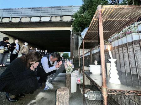 　関越道ツアーバス事故から１３年となり、現場近くの献花台で手を合わせる関係者＝２９日午前、群馬県藤岡市（代表撮影）