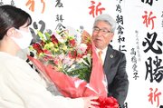 初当選を祝う花束を長女から受け取り、笑顔を見せる朝倉和仁氏＝１４日午後１０時２８分、安八郡輪之内町中郷の選挙事務所