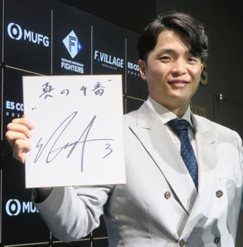 　契約更改交渉を終えて色紙を手にポーズをとる日本ハム・郡司＝３日、エスコンフィールド北海道