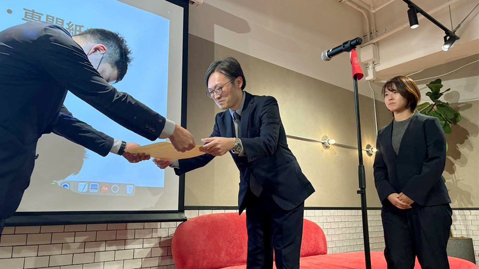 西田亮介選考委員（左）から表彰状を受ける山田俊介記者（中央）と坂井萌香記者（右）＝７日午後、東京都渋谷区、スマートニュース本社